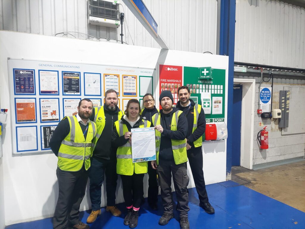 Andover team stood in the warehouse with certificate