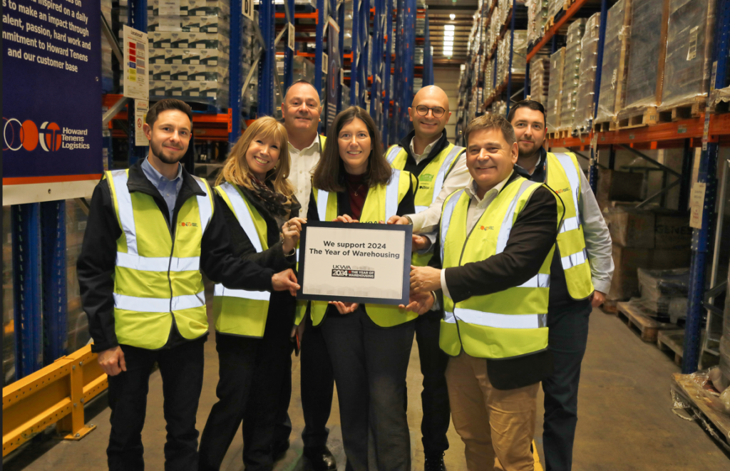Howard Tenens employees, members of UKWA and local MP pose in warehouse for campaign support photo.