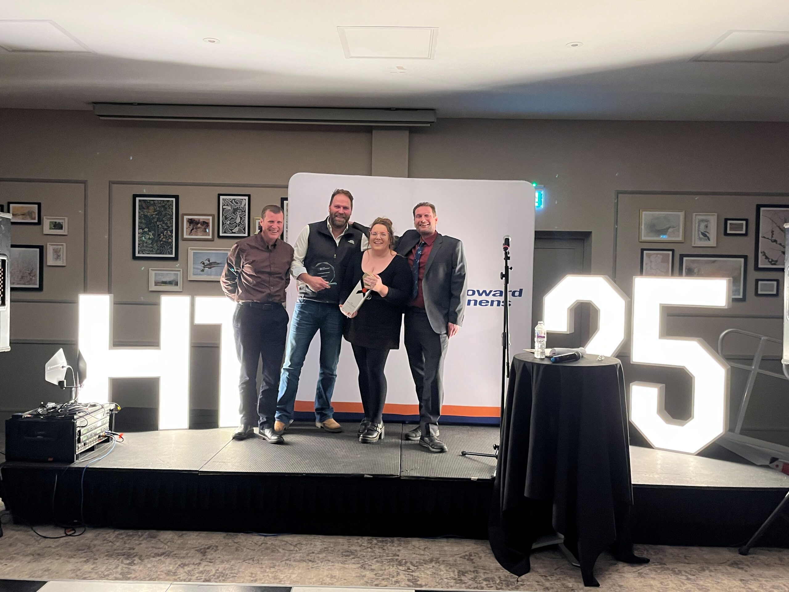 Award winner stood on stage with stakeholders