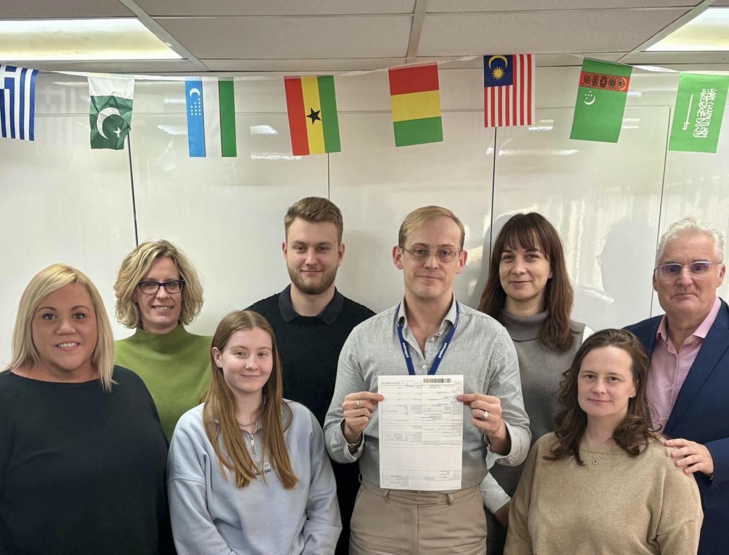 Group of people stood with brokerage certificate