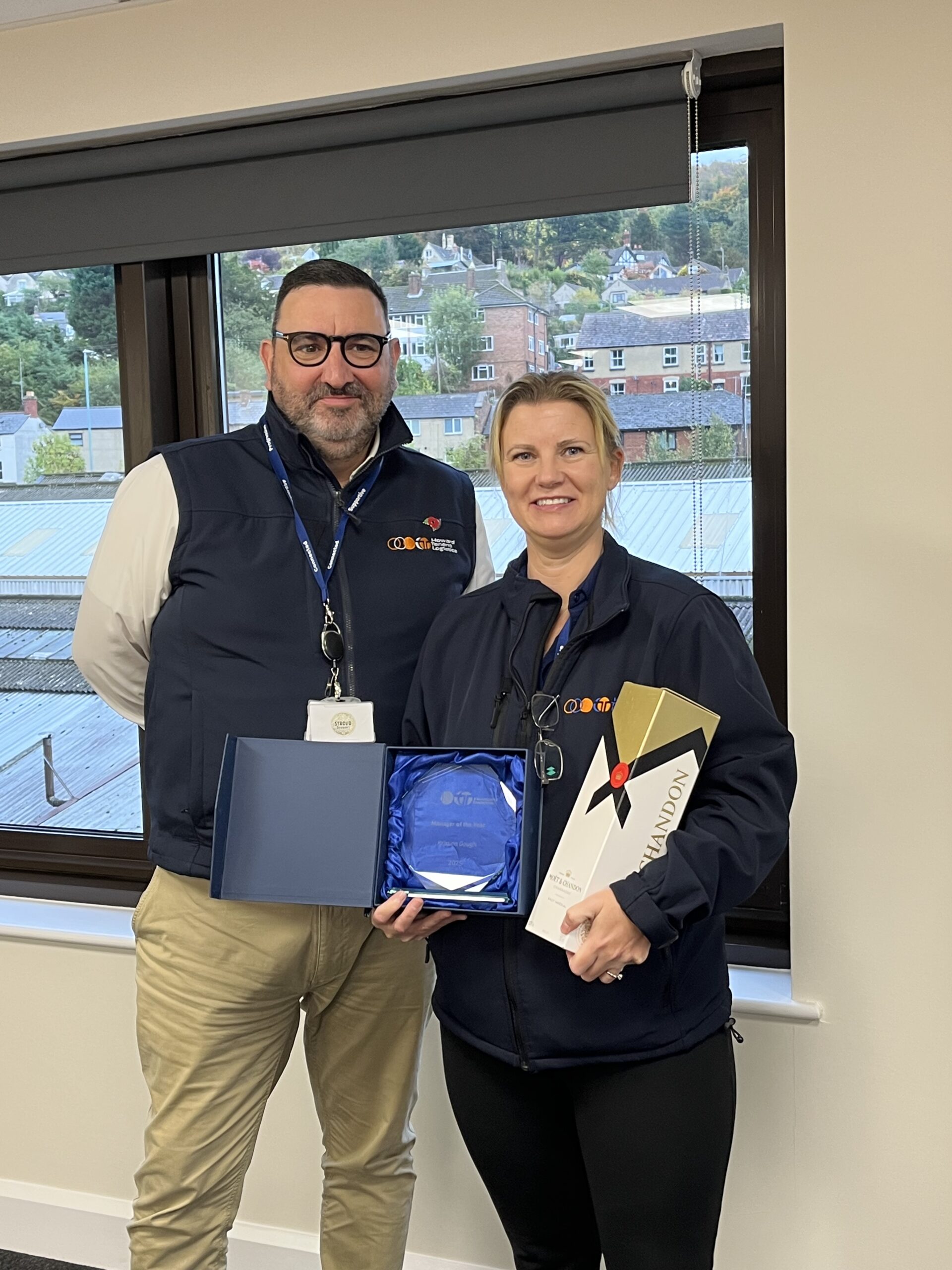 Award winner stood with manager holding award and champagne